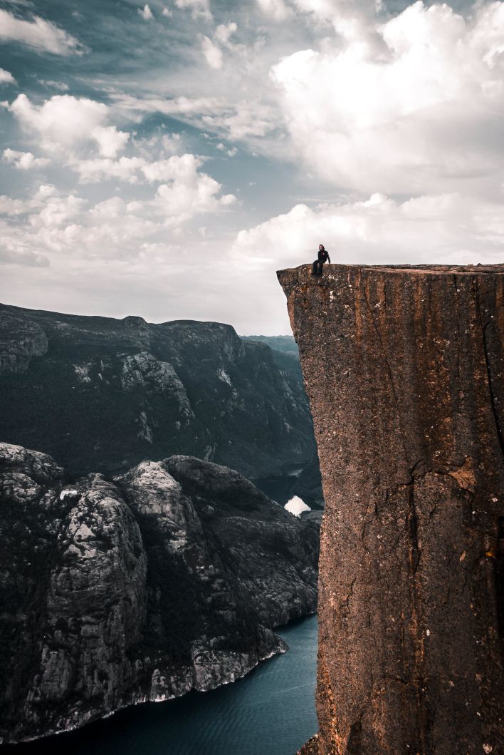 People Sitting on the Edge of a Cliff