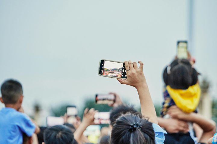 A lively crowd capturing an event on smartphones, showcasing modern digital engagement.